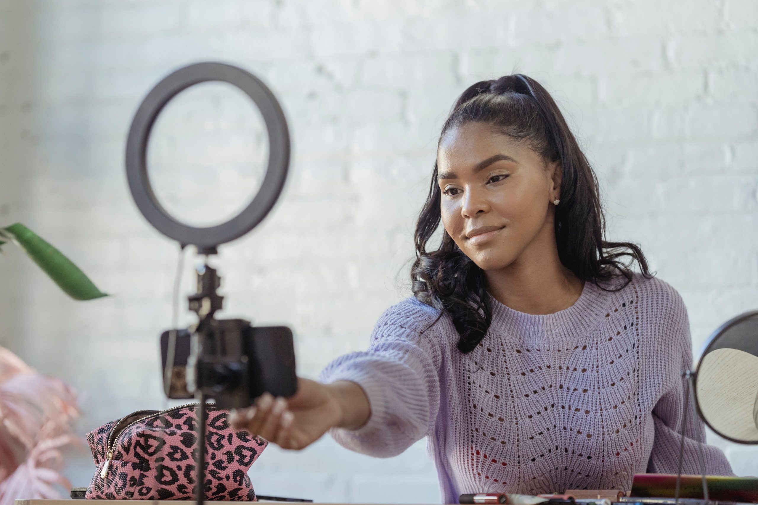 Content creator recording with a smartphone and ring light, representing an AI digital twin workflow