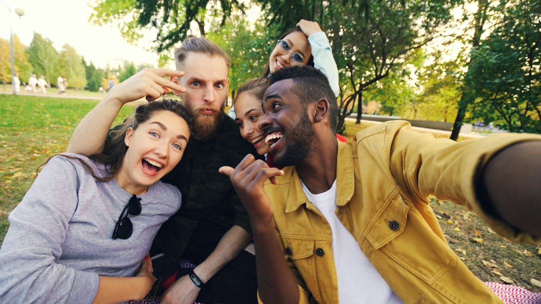 Friends taking a group photo outdoors, illustrating the privacy of people represented in connected AI social conversations
