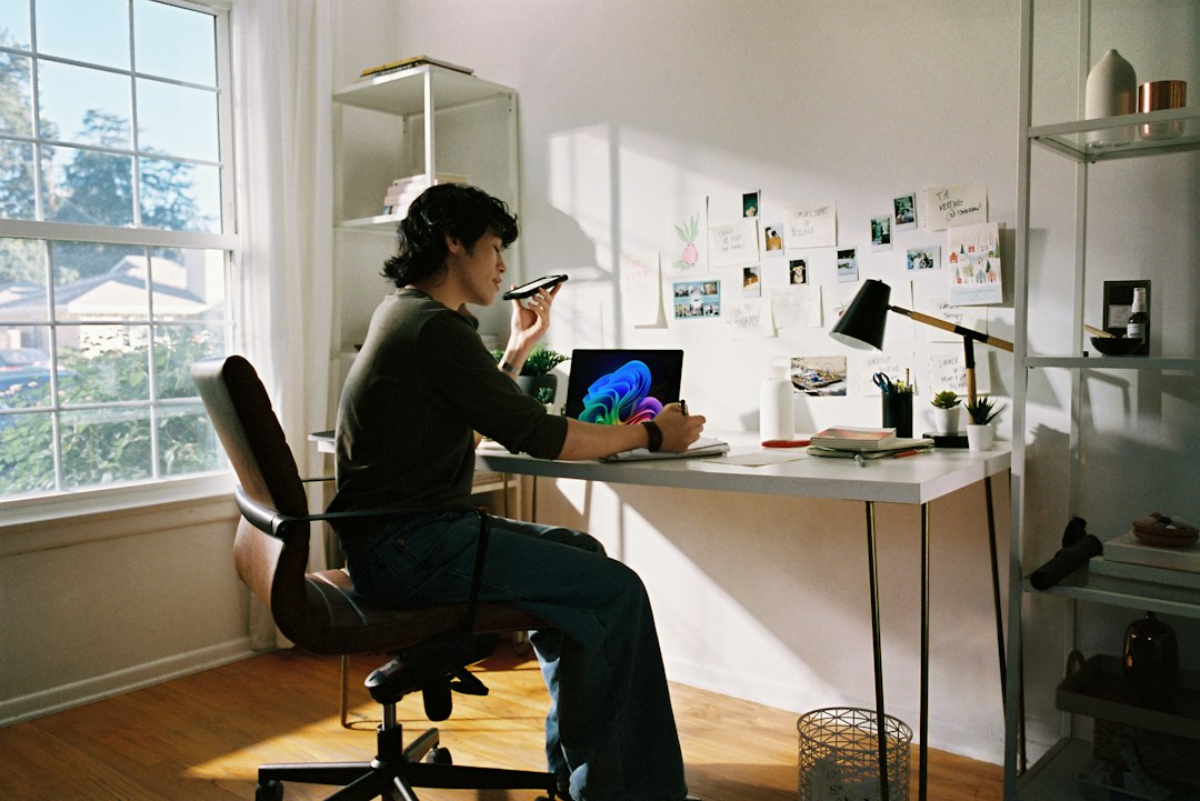 Person working at laptop and phone illustrating session privacy controls for AI digital human video calls